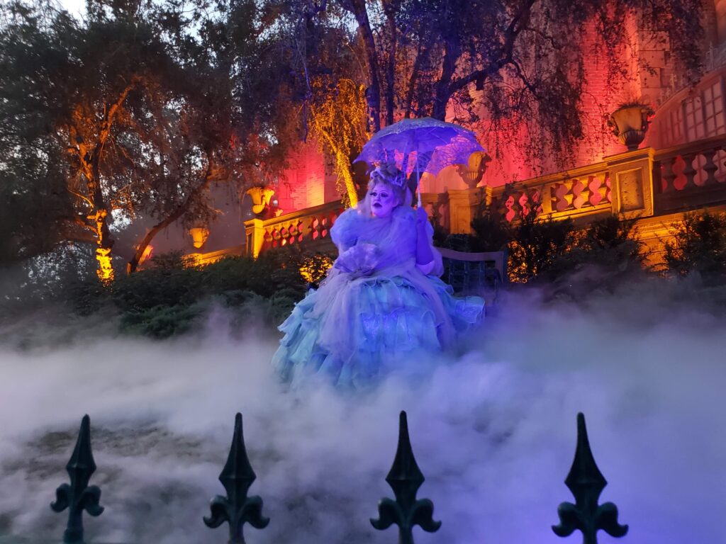 Disney Character in costume in front of Haunted Mansion